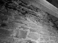 PAŘÍŽOV: pohled z podkroví lodi na východní zeď věže s rozhraním mezi stěnou s rytými spárami ve spodní části a horním lomovým zdivem bez povrchové úpravy (foto M. Falta 2010).